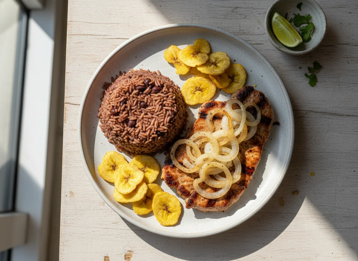 Plato cubano con arroz congrí, bistec de cerdo y chicharritas de plátano photo