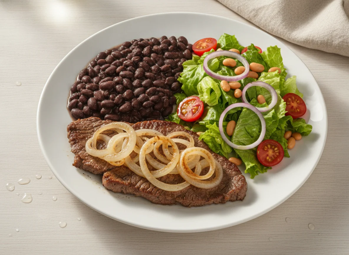 Bife acebolado com feijão preto e salada mista photo